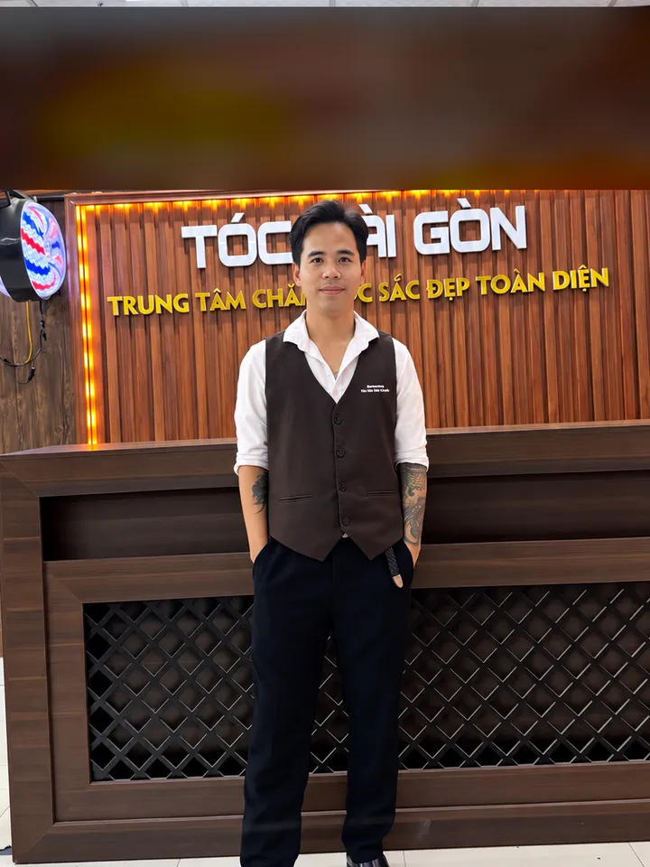 Thịnh Nguyễn, chuyên gia tạo mẫu tóc, đứng trước quầy lễ tân