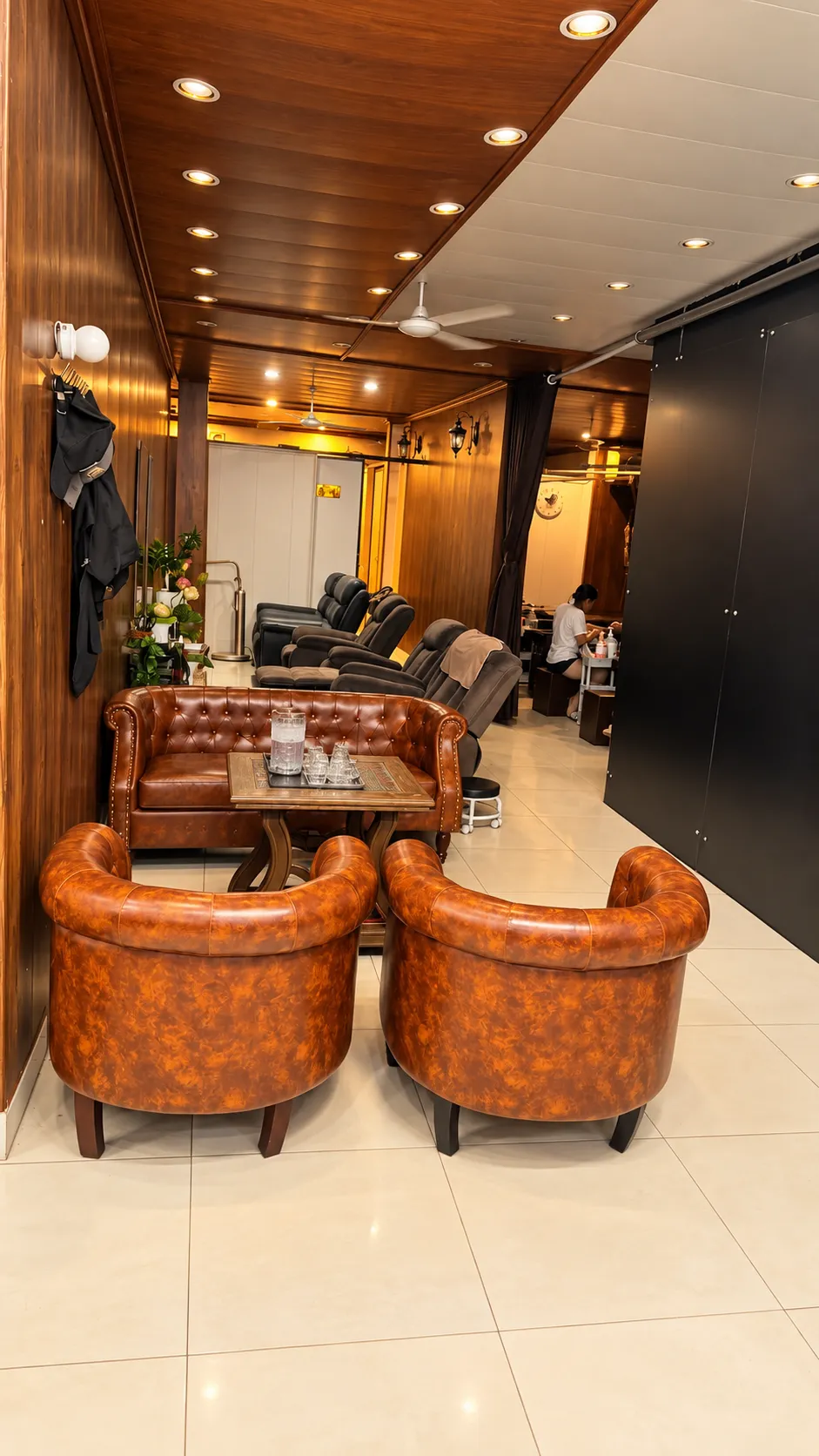 Khu chờ có sofa da nâu và ghế thư giãn tại TÓC SÀI GÒN